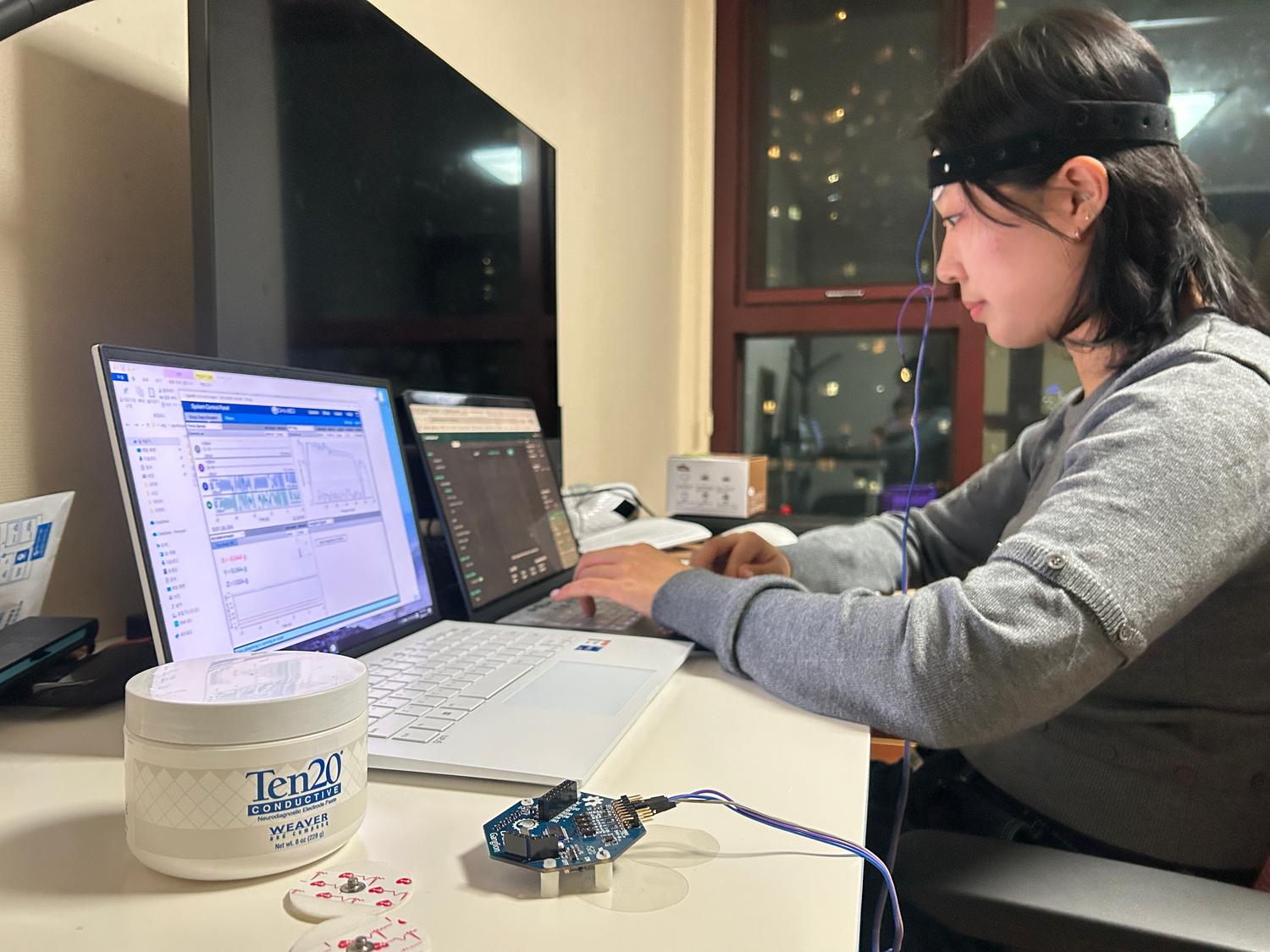 EEG data collection session with OpenBCI headset, electrode paste, and live signal monitoring